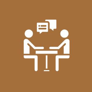 Two people talking at a table icon.